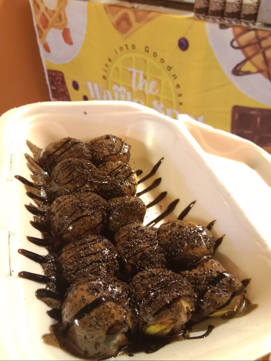 Twelve piece box of Oreo waffle balls with chocolate sauce